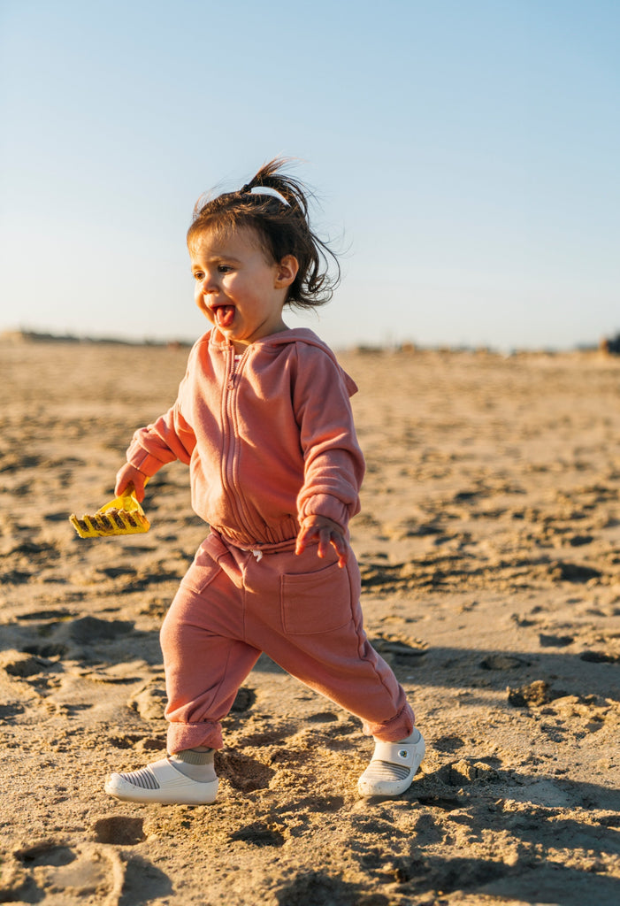 A happy kid exploring the beach in jbrds’ hypoallergenic baby shoes.